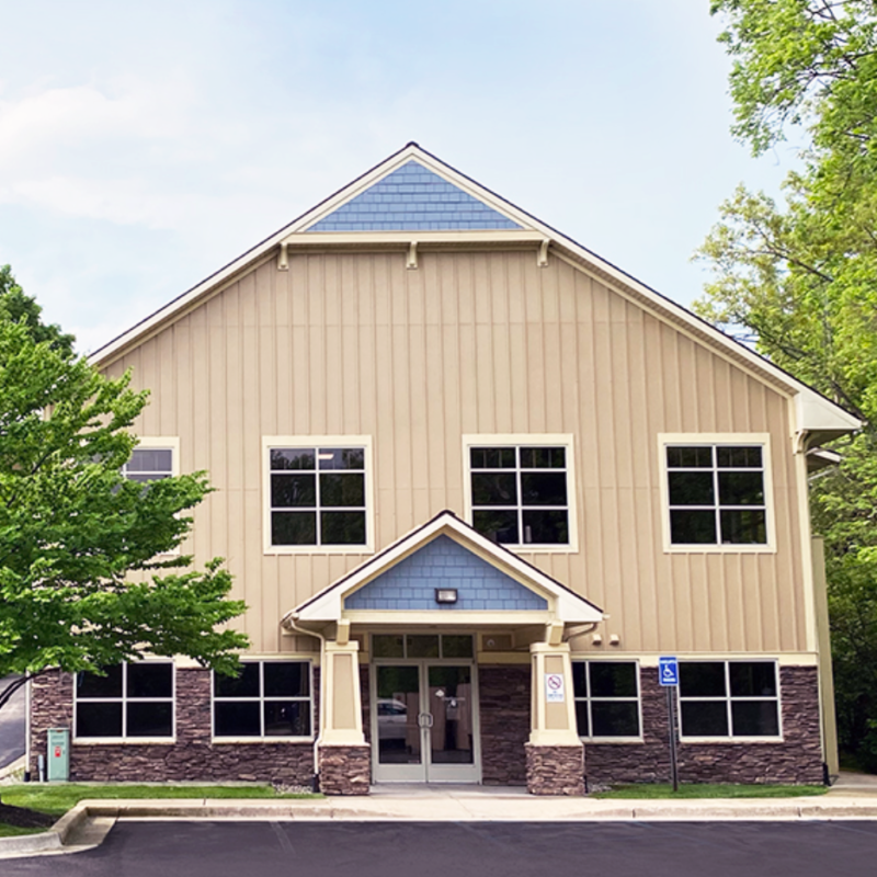 Exterior of the original Daydreams Procedure Center building, a tan two-story building among trees